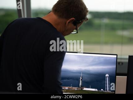 SpaceX Demo-2 Launch Attentat Hans Koenigsmann, Vice President für Build and Flight Reliability bei SpaceX, Schaut auf einen Monitor, der einen Live-Feed einer SpaceX Falcon 9 Rakete zeigt, die die Crew Dragon Raumsonde des Unternehmens während des Countdowns für einen Startversuch der NASA-Mission SpaceX Demo-2 mit den NASA-Astronauten Robert Behnken und Douglas Hurley an Bord trägt, Mittwoch, 27. Mai 2020, Im Schussraum vier des Launch Control Center im Kennedy Space Center der NASA in Florida. Die NASA SpaceX Demo-2 Mission ist der erste Start mit Astronauten der Raumsonde SpaceX Crew Dragon und F Stockfoto