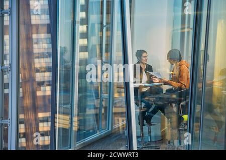 Geschäftsleute treffen sich am Bürofenster im Hochhaus Stockfoto