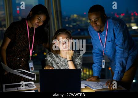 Geschäftsleute, die sich spät am Laptop im Büro Stockfoto
