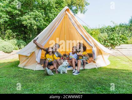Glückliche Familie, die Selfie im Zelt im Sommergyard macht Stockfoto