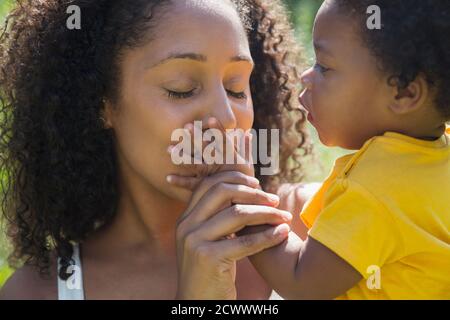 Nahaufnahme liebevolle Mutter küsst Hand von Kleinkind Tochter Stockfoto