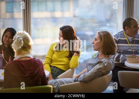 Geschäftsleute, die sich in der Bürokantine unterhalten Stockfoto