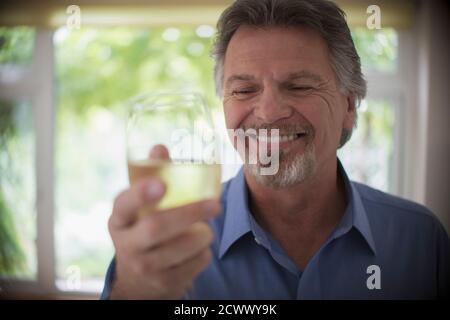 Nahaufnahme lächelnder älterer Mann, der Weißwein trinkt Stockfoto