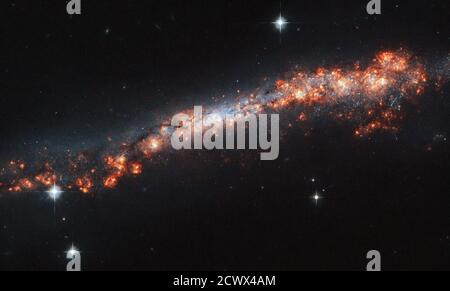 Das Hubble-Weltraumteleskop erfasst die Galaxie NGC 3432, eine Spiralgalaxie, die von der Erde aus gesehen wird. Das Bild zeigt kosmische Staubbänder und Bereiche der Sternentstehung, die nur die äußersten Bereiche der Struktur zeigen. Stockfoto