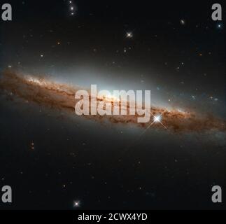 Das NASA/ESA Hubble Space Telescope erfasst eine atemberaubende Profilansicht der Spiralgalaxie NGC 3717, die sich 60 Millionen Lichtjahre entfernt im Hydra-Sternbild befindet. Das Bild hebt die dreidimensionale Spiralstruktur der Galaxie hervor. Stockfoto