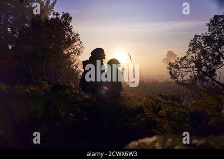 Silhouette ruhiges junges Paar genießen Wanderung in der Natur bei Sonnenuntergang Stockfoto