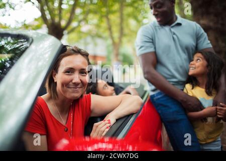 Portrait glückliche Frau mit Familie bei Cabrio Stockfoto