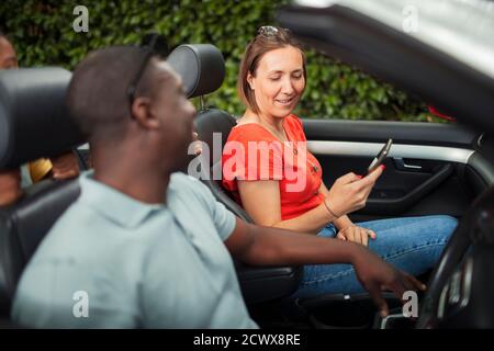 Paar mit Smartphone in Convertible Stockfoto