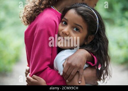 Portrait niedlich Mädchen umarmt Schwester Stockfoto