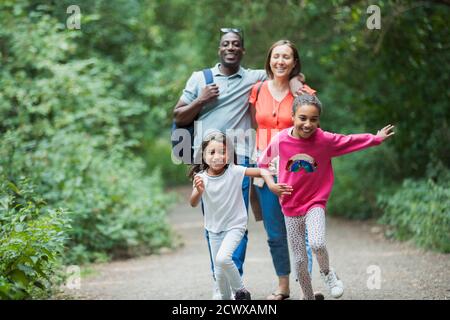 Glückliche Familie laufen und Wandern auf dem Weg in Wäldern Stockfoto