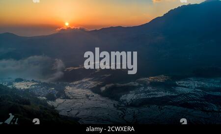 (200930) -- KUNMING, 30. September 2020 (Xinhua) -- Luftfoto vom 4. April 2019 zeigt terrassenförmige Felder bei Sonnenaufgang im Bezirk Yuanyang, südwestlich von Chinas Provinz Yunnan. Obwohl Yunnan nur 4.1 Prozent der Landfläche Chinas ausmacht, gilt die Provinz noch als "Königreich der Tiere und Pflanzen" und "Gene Bank of Species", weil sie mehr als 50 Prozent der biologischen Arten des Landes beherbergt. In den letzten Jahren hat China mit der Durchsetzung von Gesetzen, Politiken und anderen Maßnahmen, wie dem Bau von Nationalparks und einem Verbot, bedeutende Erfolge im ökologischen Naturschutz erzielt Stockfoto