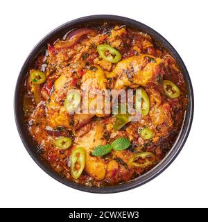 Ein Huhn Patiala in schwarzer Schale isoliert auf weiß. Murg Patiala ist ein Currygericht der indischen Küche mit Hühnerfleisch, Gewürzen, Quark und Cashewnuss-Paste. Asi Stockfoto