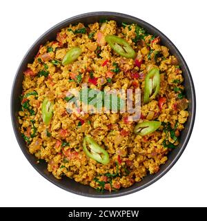 Masala Ei Bhurji oder Muttai Podimas in schwarzer Schale isoliert auf weiß. Anda Bhurji ist indische Küche Rühreier Gericht mit Gewürzen. Asiatische Küche und Mea Stockfoto