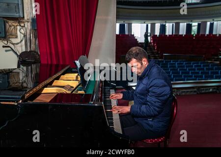 YMCA Peace Project Teilnehmer Gerog Sargsyan trifft sich wieder mit anderen Teilnehmern im Theater der kleinen Stadt Martouni in Berg-Karabach, etwa fünf Kilometer von der Front entfernt, und spielt Klavier. Die Kaukasusrepublik wird zwischen Armenien und Aserbaidschan geführt. Stockfoto