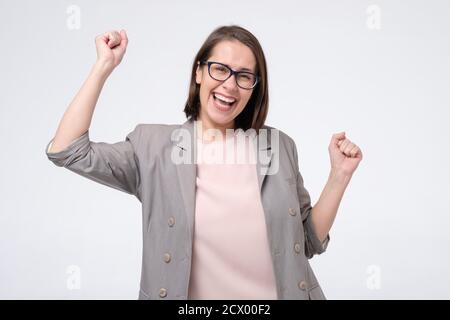 Reife kaukasische Frau in der Brille tun einen Gewinner Geste heben Fäuste hoch Stockfoto