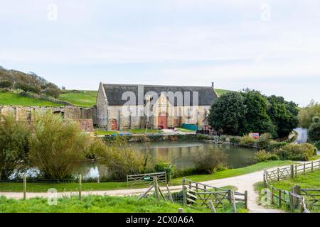 Die große Zehenscheune und der Teich an den Ruinen der Abbotsbury Abbey, einem ehemaligen Benediktinerkloster in Abbotsbury, Devon, Südostengland Stockfoto