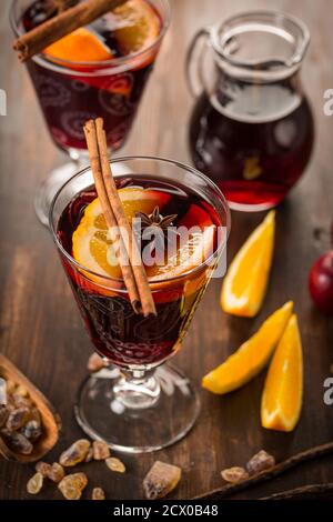 Glühwein Heißgetränk mit Zitrusfrüchten, Apfel und Gewürzen auf Holz Hintergrund. Stockfoto