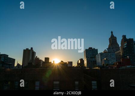 Die Sonne untergeht unter den East Village Gebäuden in New York City. Stockfoto