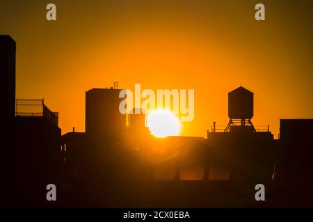 Die Sonne untergeht unter den East Village Gebäuden in New York City. Stockfoto