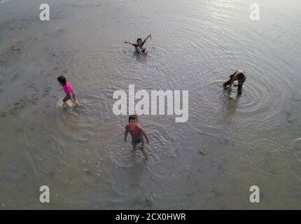 Penaga, Penang/Malaysia - Nov 03 2019: Asiatisch-malaysische Kinder spielen schlammig im Reisfeld. Stockfoto