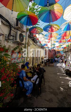 George Town, Penang/Malaysia - Nov 11 2019: Eine Familie ruht sich mit einem bunten Regenschirm auf der Straße aus. Stockfoto