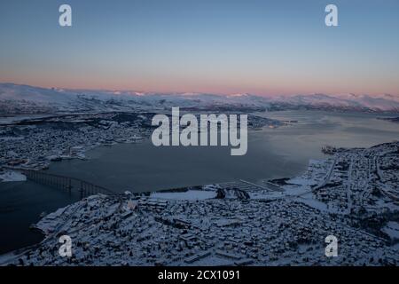 Tromsø Norwegen Stadtbild im Winter mit Schnee bedeckt. Blick auf die Meerenge von Tromsøysundet. Vogelperspektive. Luftaufnahme. Stockfoto