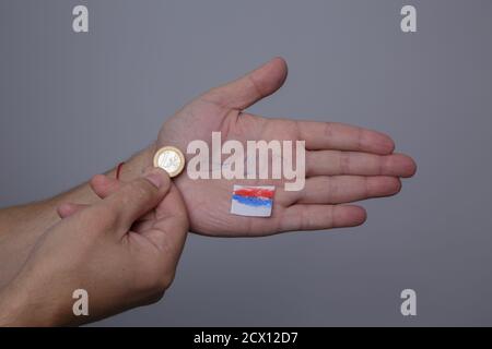 Man Hand hält Euro-Münze und auf der anderen Handfläche Der Kurs von 100 Rubel wird geschrieben Stockfoto
