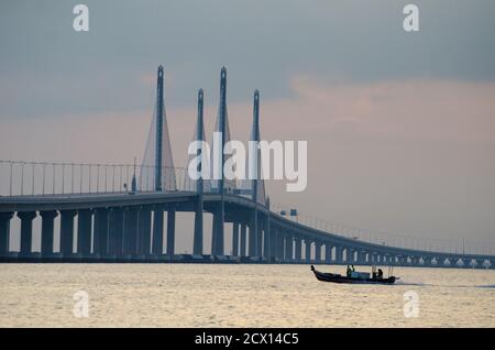 George Town, Penang/Malaysia - Dez 28 2019: Ein seufzender Boot fährt in Richtung der Hauptspannweite der Penang Second Bridge. Stockfoto