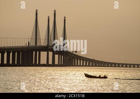 George Town, Penang/Malaysia - Dez 28 2019: Fischerboot bewegt sich in der Nähe der Penang Second Bridge. Stockfoto