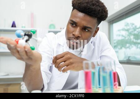 Wissenschaftler in einem Labormantel mit molekularen Modellen Stockfoto