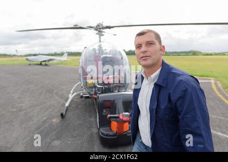 Männlicher Pilot überprüft Hubschrauber vor dem Flug Stockfoto