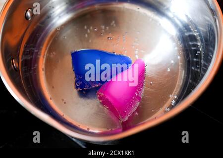 Menstruationstasse in heißem Wasser. Vor dem ersten Gebrauch kochen. Stockfoto