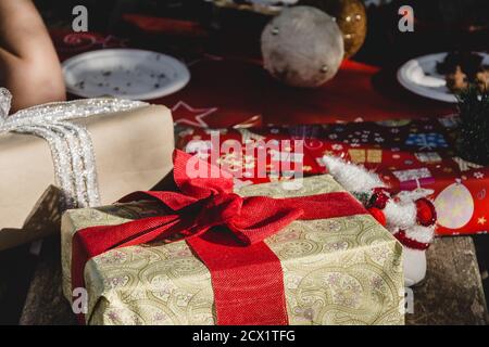 Ein Landtisch mit Geschenken und Weihnachtsartikeln während dekoriert Ein weihnachtliches Picknick in der Natur Stockfoto