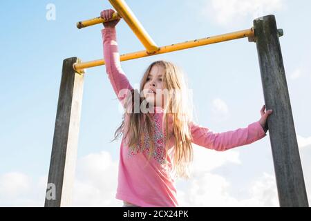 Junges Mädchen auf Spielgeräte im Park Stockfoto