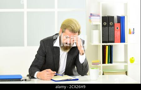 Schadenverhütungsplan Wirtschaftskrise. Börsen- und Konjunkturzyklen. Mann bärtig Manager formell Anzug sitzen Büro. Investmentpapiere wie Aktien Anleihen und Investmentfonds. Krisenkonzept. Stockfoto