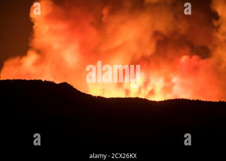 Silhouette Berg mit Wildfeuer im Hintergrund in der Nacht Stockfoto