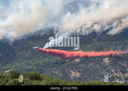 Flugzeuge, die feuerhemmend auf Waldbrände entlädt Stockfoto