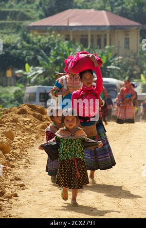 Hmong Mutter und Kinder zu Fuß in Can CAU Markt, in der Nähe Bac Ha, Lao Cai Provinz, Vietnam Stockfoto