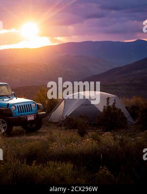 Geländewagen im Zelt auf dem Feld bei Sonnenuntergang Stockfoto