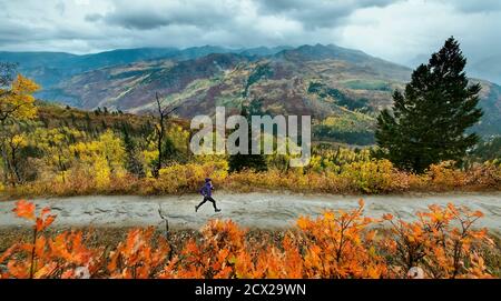 Frau, die im Herbst auf der Straße läuft Stockfoto