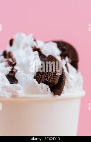 Eis in einer Tasse mit Schokolade und Keksen Ein rosa Hintergrund Stockfoto