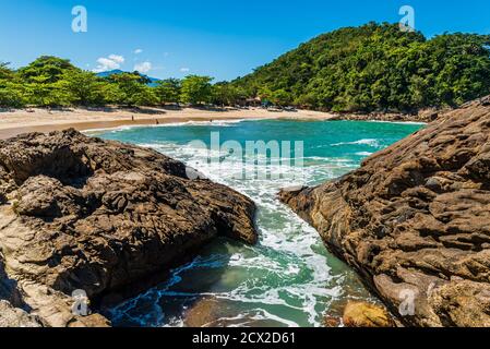 Kleiner Strand in einer wilden tropischen Landschaft, von Felsen aus gesehen Am Ufer Stockfoto