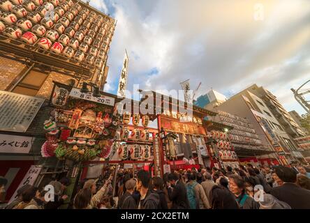 asakusa, japan - november 08 2019: Massen agglutinierten am Tor des Ootori-Schreins, geschmückt mit Papierlaternen, um verheißungsvolle Bambusrechen zu kaufen Stockfoto