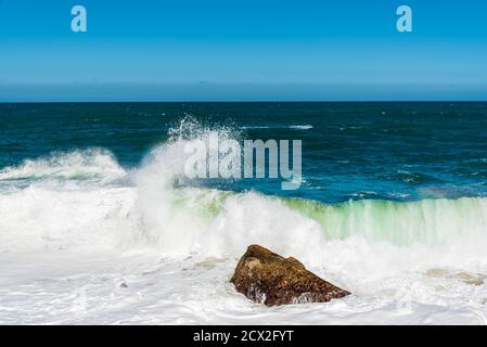 Meereswelle fließt in Richtung Felsen am Strand Stockfoto