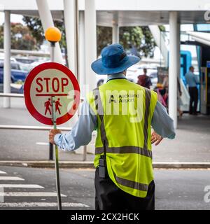 Auckland, Neuseeland: Grenzschutz mit Stoppschild an einer Zebrakreuzung vor dem Terminal des Auckland International Airport Stockfoto