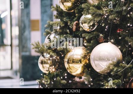 Festliche Outdoor dekorative weihnachtsbeleuchtung Hintergrund. Weihnachtsbaum Zweig mit Kugeln geschmückt, Kugeln auf architektonischen Wahrzeichen Hintergrund. Stockfoto