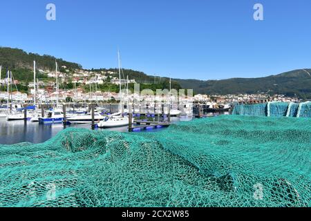 Muros, Spanien. Juni 18, 2020. Hafen und Dorf mit Fischernetz, Segelbooten und Fischerbooten in der berühmten Rias Baixas in Galicien Region. Stockfoto