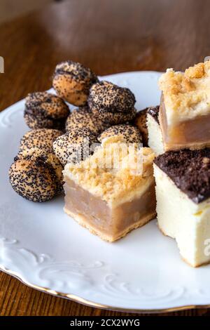 Auswahl von polnischen Kuchen und Plätzchen - Szarlotka (Apfelkuchen), Sernik (Käsekuchen) und Baletki z makiem (Mohnkuchen mit Marmelade gefüllte Sandwich-Kekse) Stockfoto