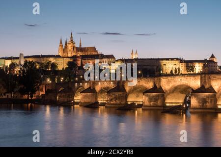 Karlsbrücke in Prag über die Moldau mit dem Veitsdom und der Prager Burg, ein Stadtbild in romantischer Dämmerung Stockfoto