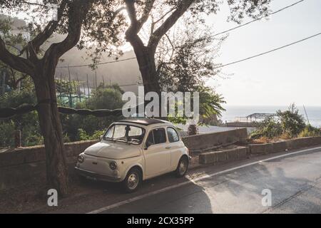 Massa Lubrense, Italien - August 23 2020: Retro, Vintage Fiat Nuova 500 Cinquecento Auto in Beige oder Elfenbein geparkt an der Sorrentinischen Küste im Sommer Stockfoto